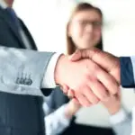Close-up of a handshake, symbolizing trust, partnership, and legal agreements.