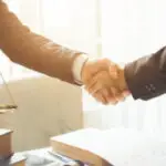 Close-up of a handshake, representing trust, partnership, and legal agreements.