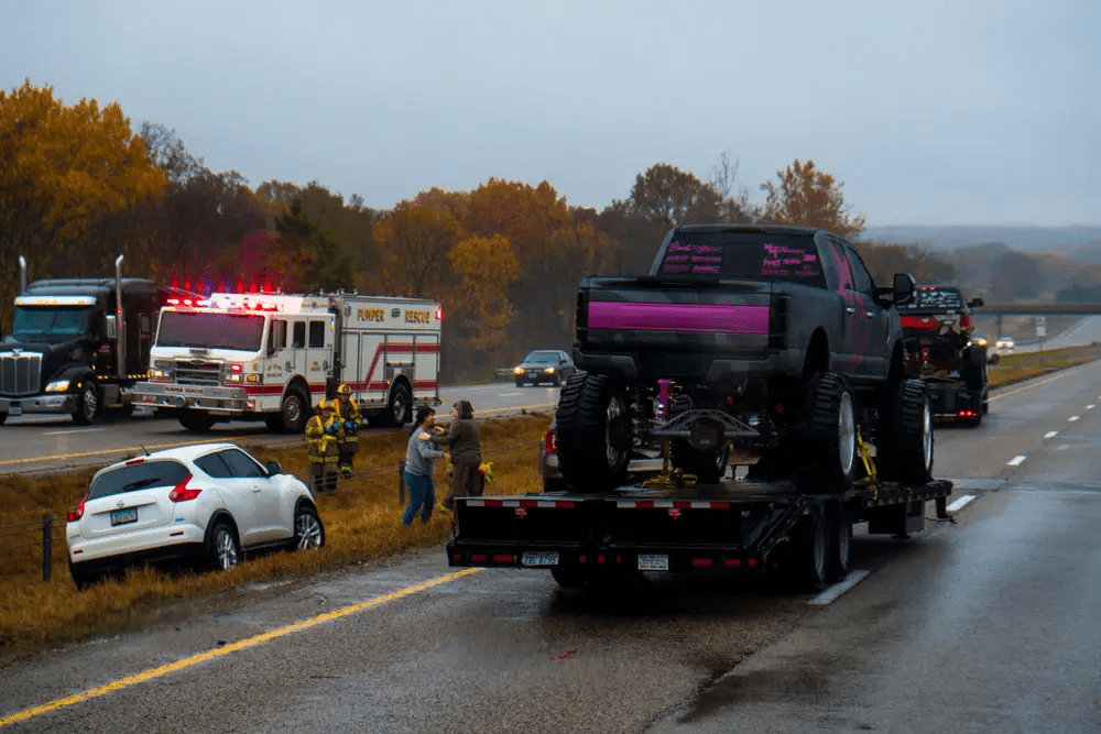Emergency response to highway accident with fire truck, damaged cars, and rescue crew.