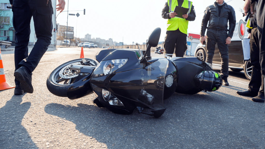 Motorcycle accident scene with traffic investigators and police on-site during daytime