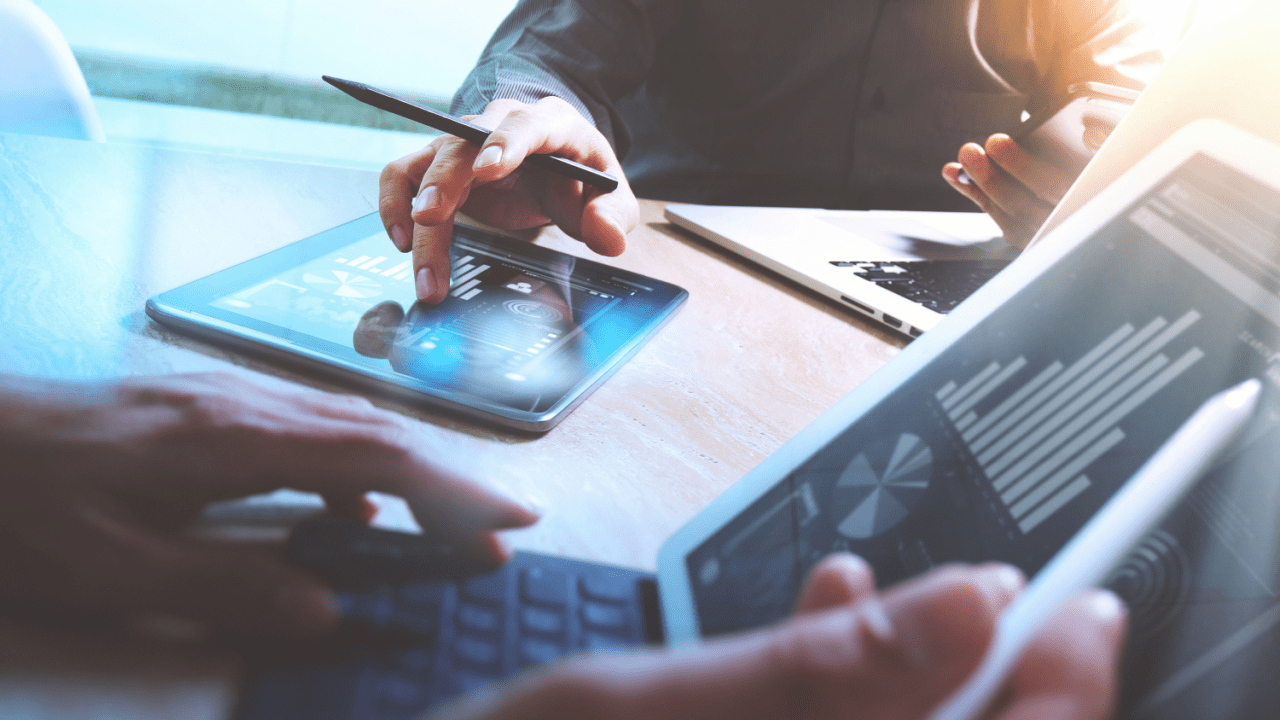 Lawyers reviewing digital lead generation reports on a tablet, analyzing client acquisition trends.