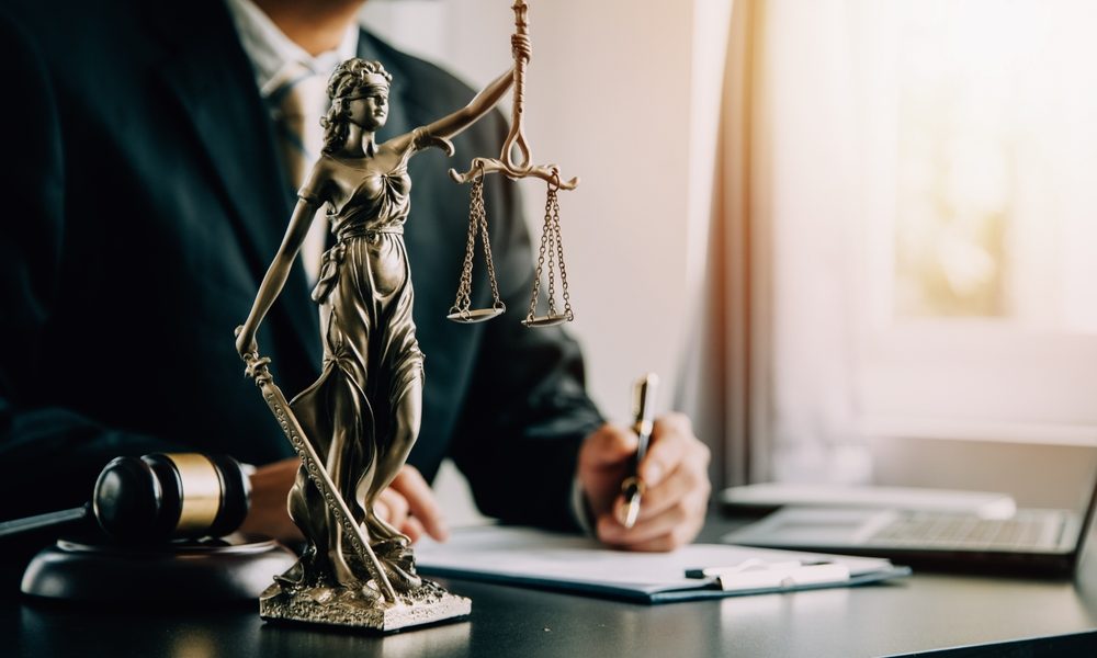 Lady Justice statue on lawyer’s desk during client consultation