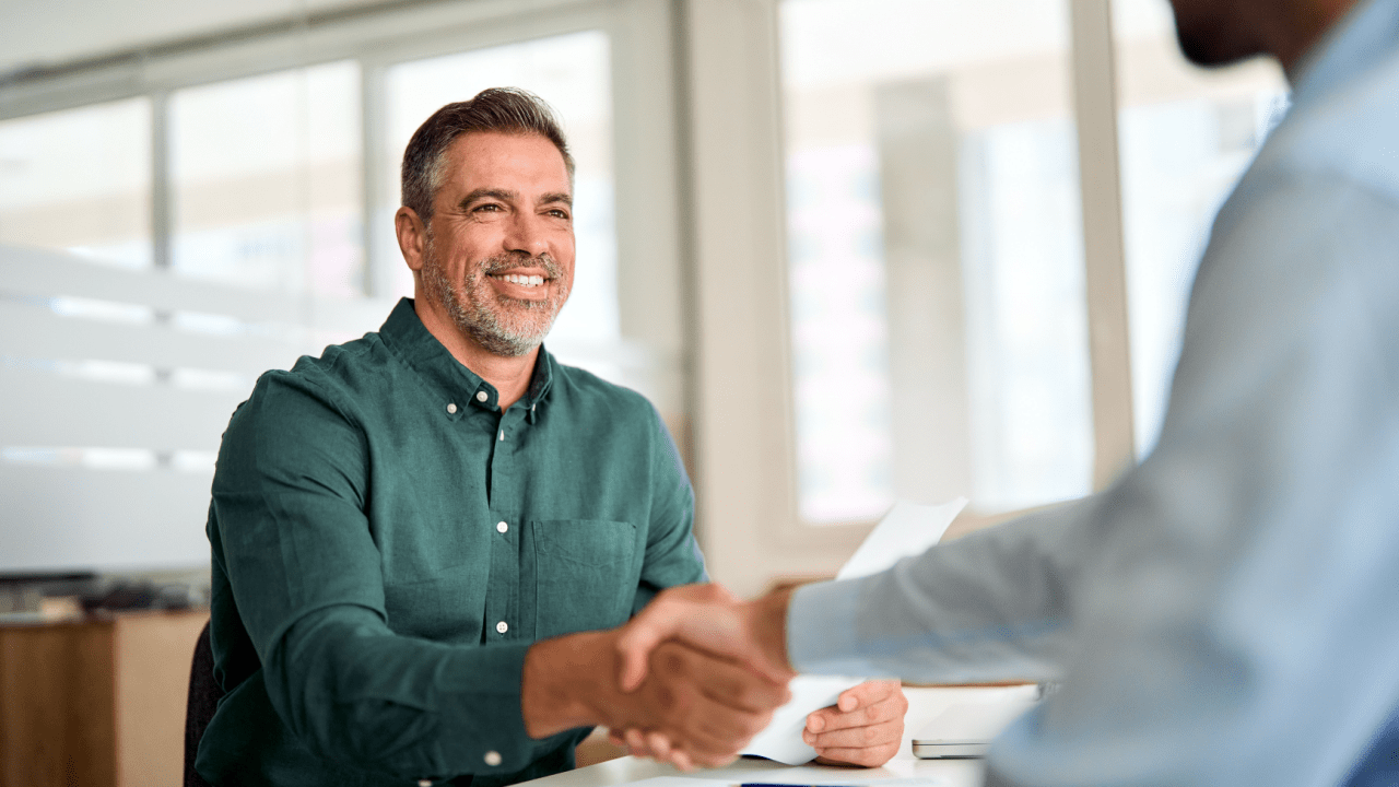 Smiling lawyer shaking hands with a client during a car accident legal consultation