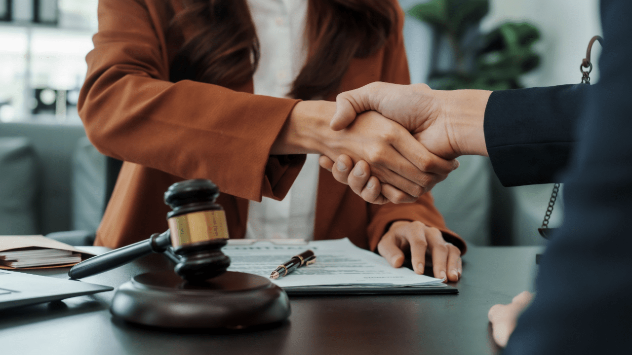 Bankruptcy attorney shaking hands with new client after successful consultation, demonstrating effective strategies on how to find bankruptcy clients
