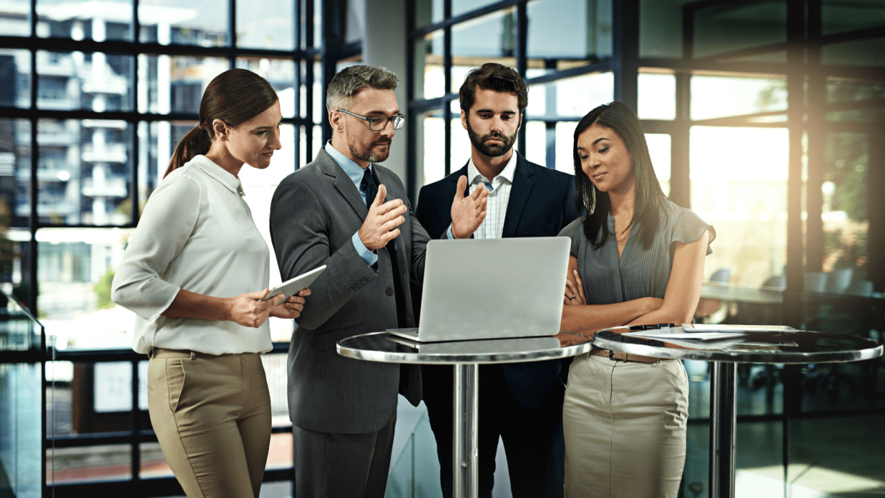 Legal team strategizing around a laptop in a modern office — how to market a criminal law practice and how hard is it to be a criminal defense lawyer.