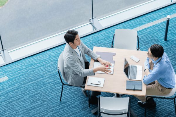 Two business professionals collaborating on marketing strategies for bankruptcy lawyers in modern office space