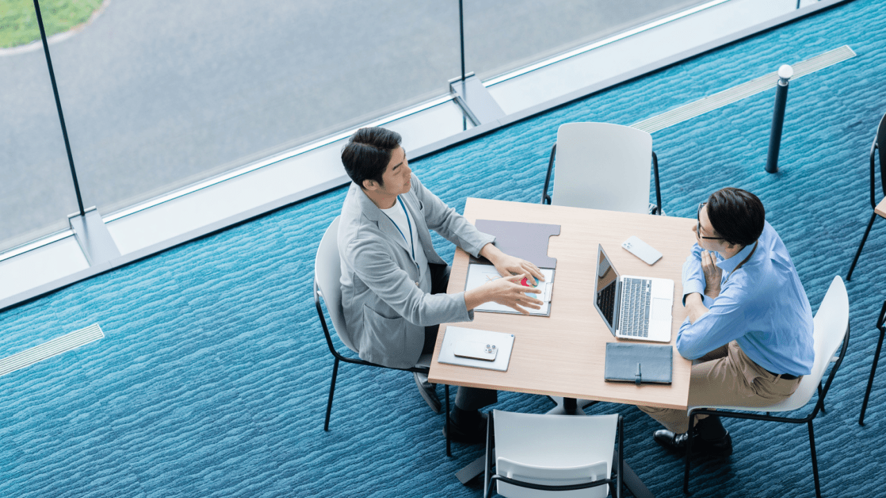 Two business professionals collaborating on marketing strategies for bankruptcy lawyers in modern office space